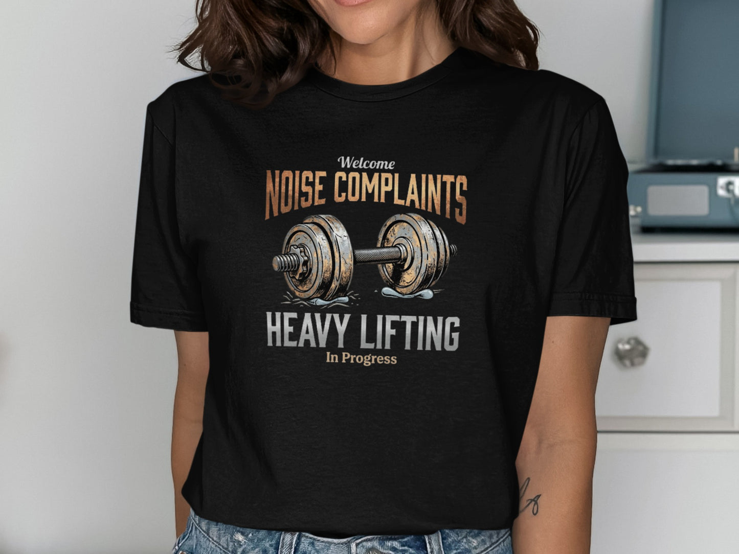Black t-shirt with "Welcome Noise Complaints Heavy Lifting In Progress" text and barbell.