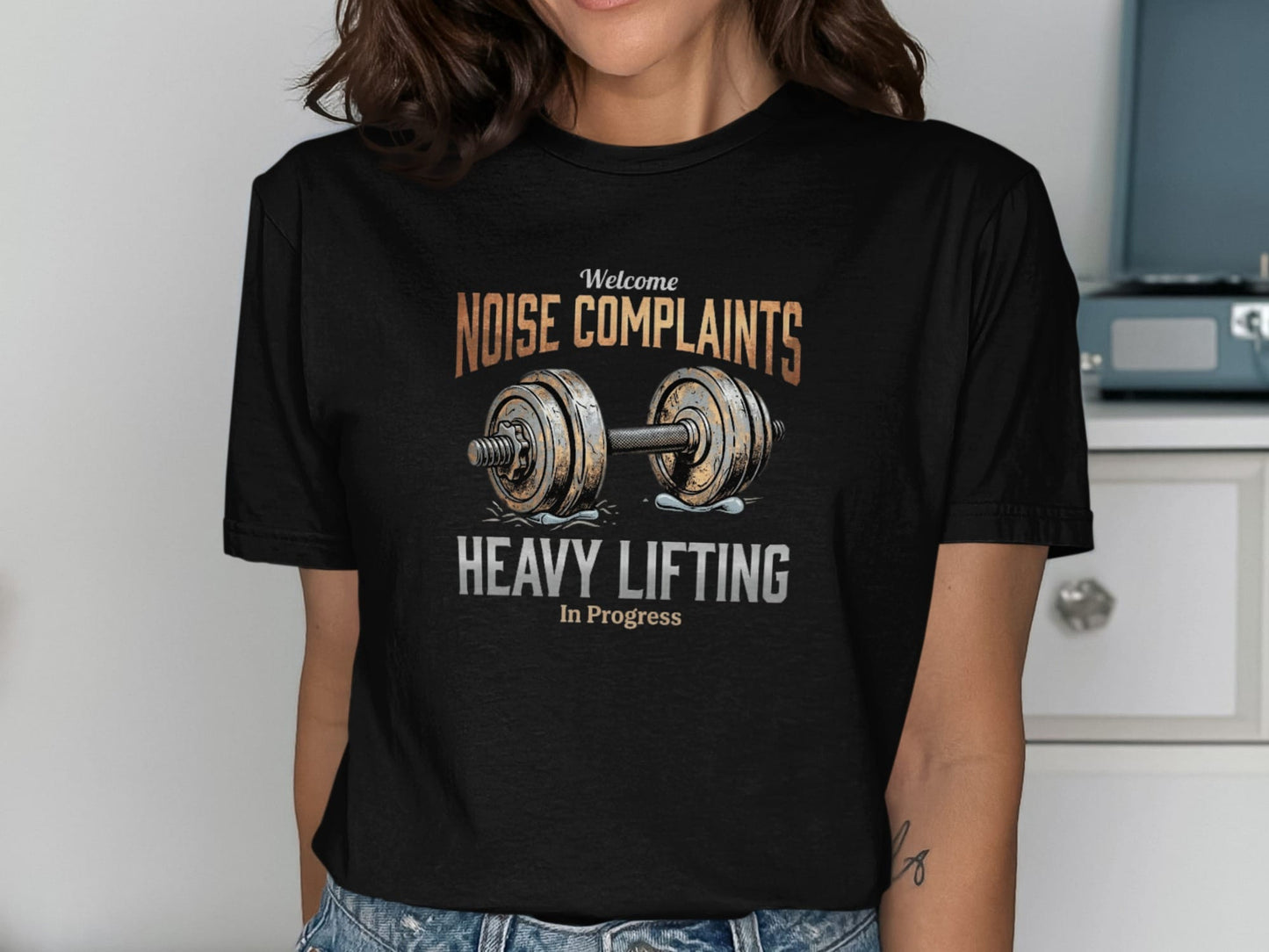 Black t-shirt with "Welcome Noise Complaints Heavy Lifting In Progress" text and barbell.