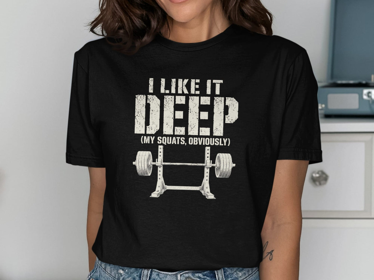 Black t-shirt with text "I LIKE IT DEEP (MY SQUATS, OBVIOUSLY)" and barbell graphic.