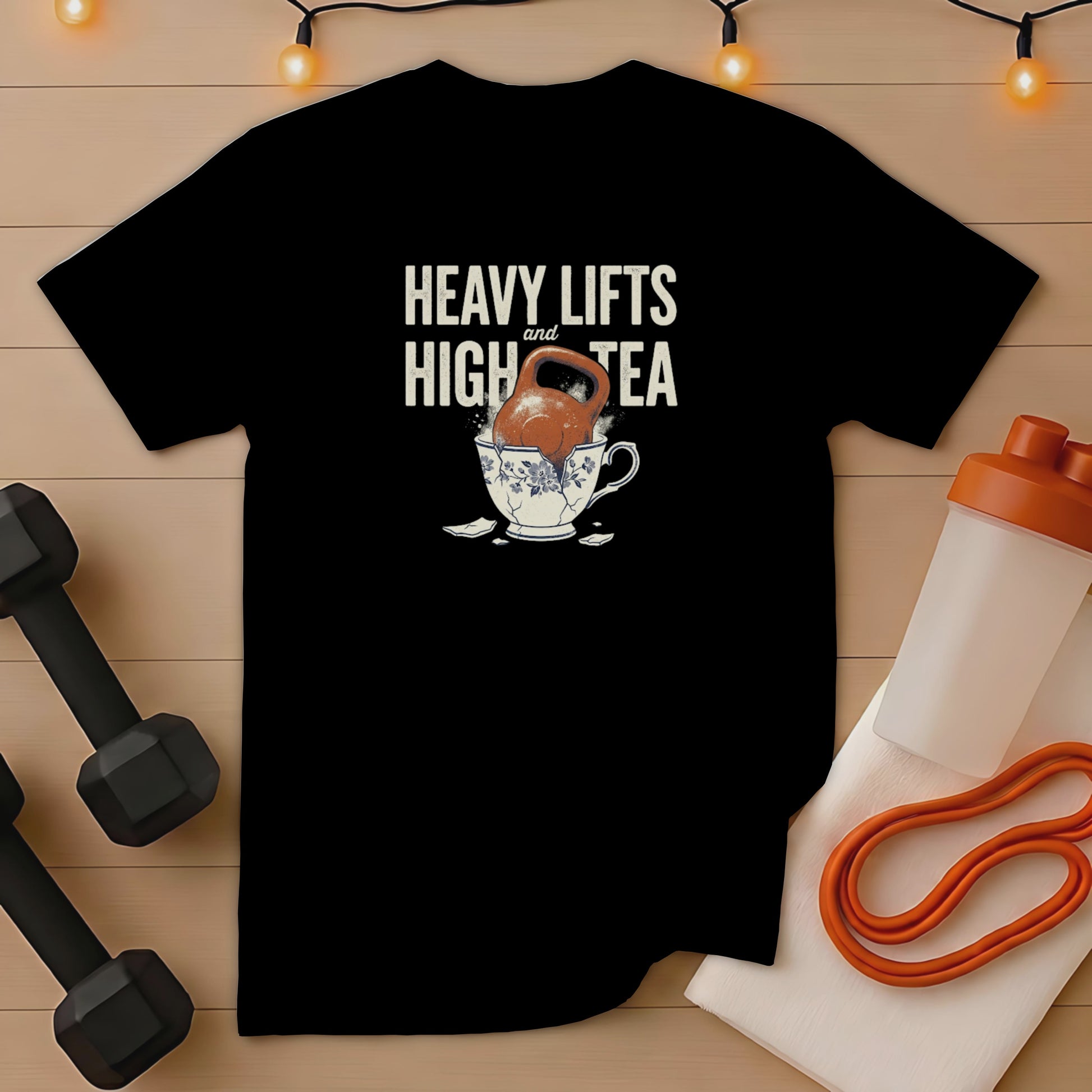 Black t-shirt with "Heavy Lifts and High Tea" text and a kettlebell in a teacup.