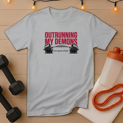 Grey t-shirt with "Outrunning My Demons" text and barbell graphic.