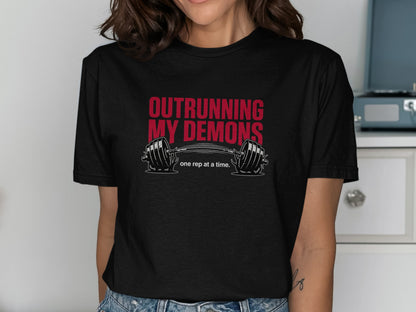 Black t-shirt with "OUTRURNING MY DEMONS" and a barbell.