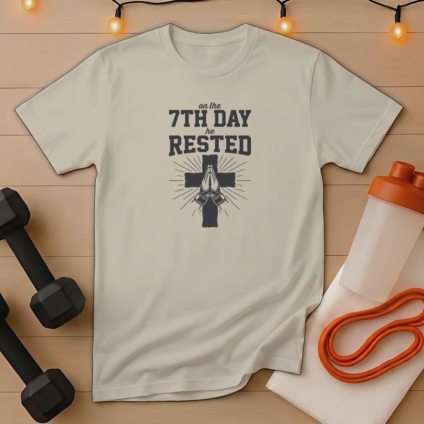 Cream t-shirt with "on the 7th DAY HE RESTED" and praying hands graphic.