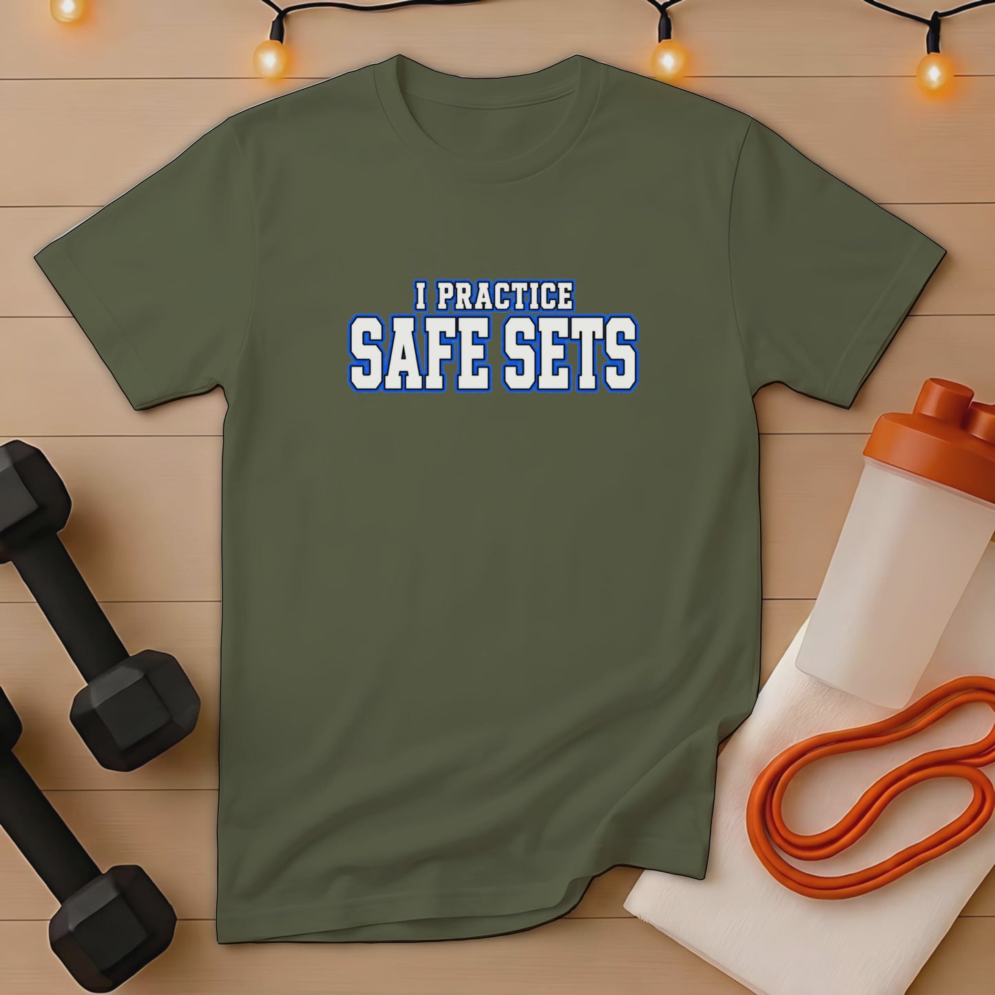 Olive green t-shirt with "I PRACTICE SAFE SETS" text, dumbbells, shaker bottle, and resistance band.