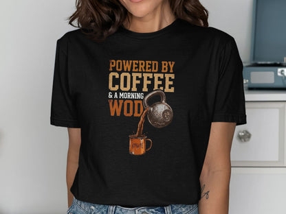 Black t-shirt graphic: "Powered by Coffee & a Morning WOD" with kettlebell pouring coffee into a mug.