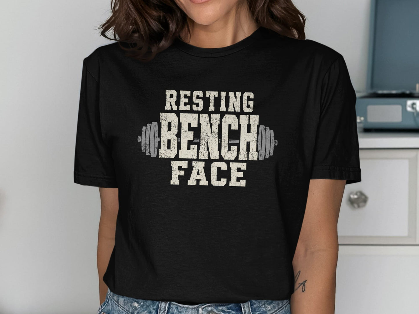 Black t-shirt with distressed "RESTING BENCH FACE" text and barbell graphic.