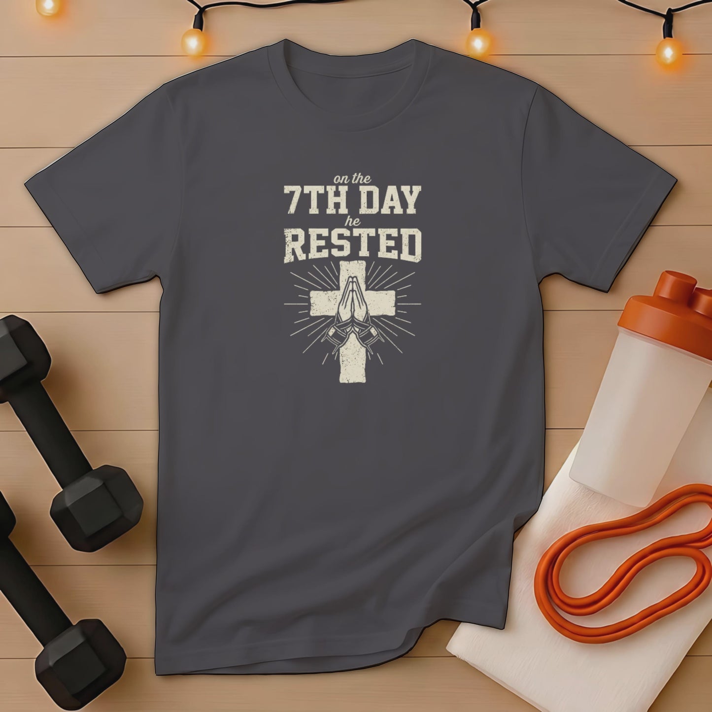 Dark gray t-shirt with "on the 7th day he rested" and praying hands.
