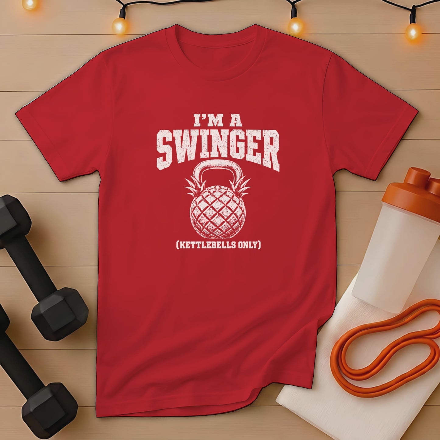 Red t-shirt with "I'm a swinger (kettlebells only)" and pineapple kettlebell graphic.