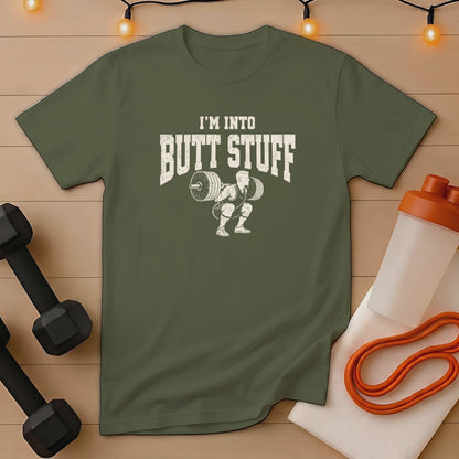 Olive green t-shirt with white text "I'M INTO BUTT STUFF" and weightlifter graphic.
