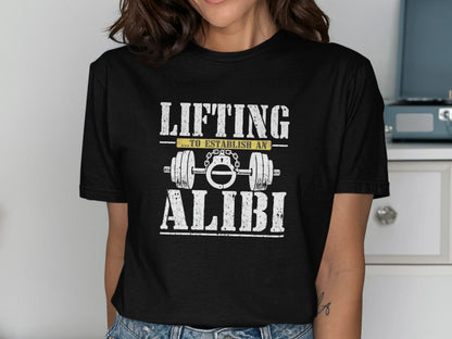 Black t-shirt with white text "LIFTING ...TO ESTABLISH AN ALIBI" and barbell graphic.