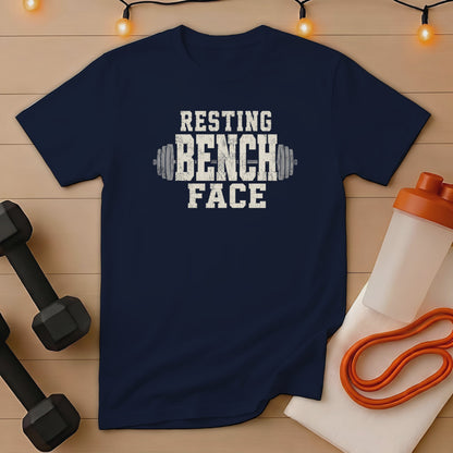 Navy t-shirt with distressed white text reading "RESTING BENCH FACE" and dumbbell graphics.
