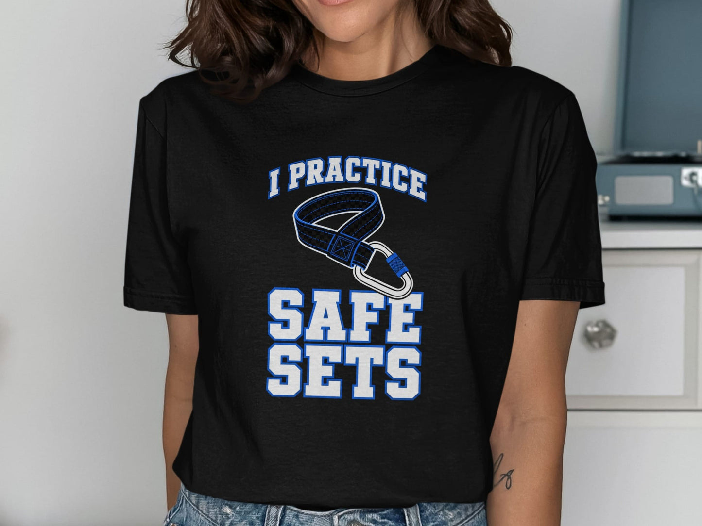 Black t-shirt with text "I PRACTICE SAFE SETS" and climbing carabiner graphic.