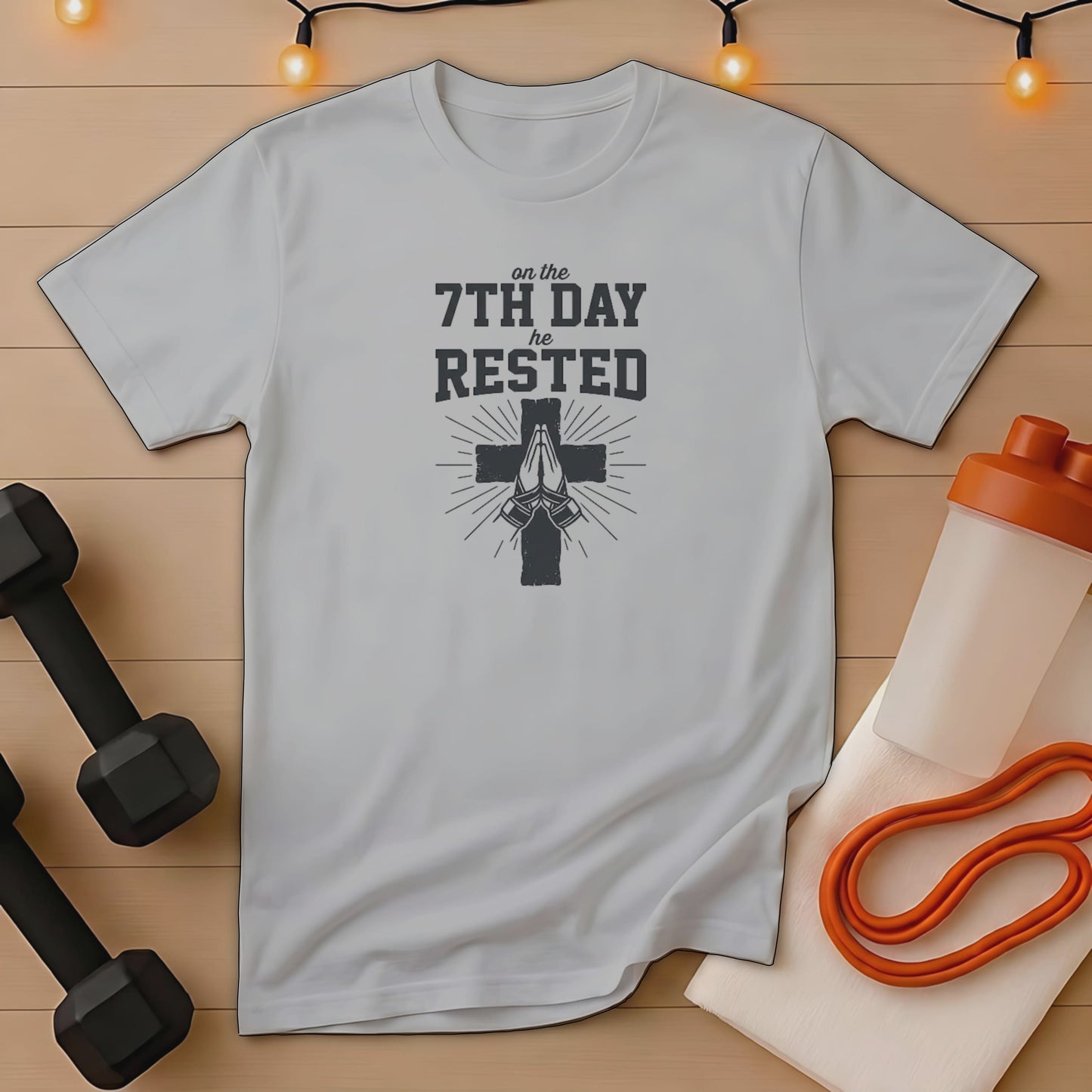 Gray t-shirt with "On the 7th Day He Rested" text and praying hands.