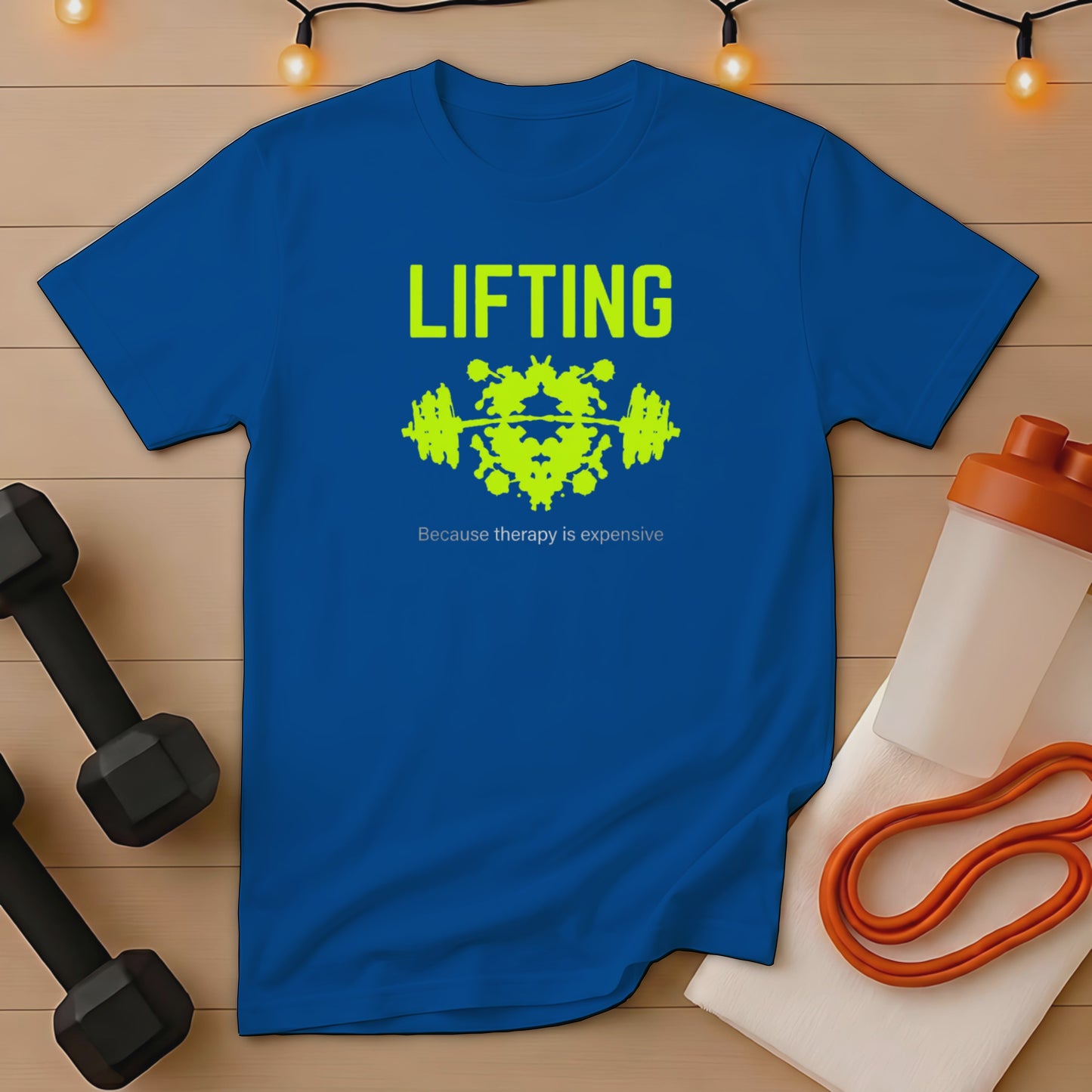 Blue t-shirt with yellow text "LIFTING because therapy is expensive" and dumbbell graphic.