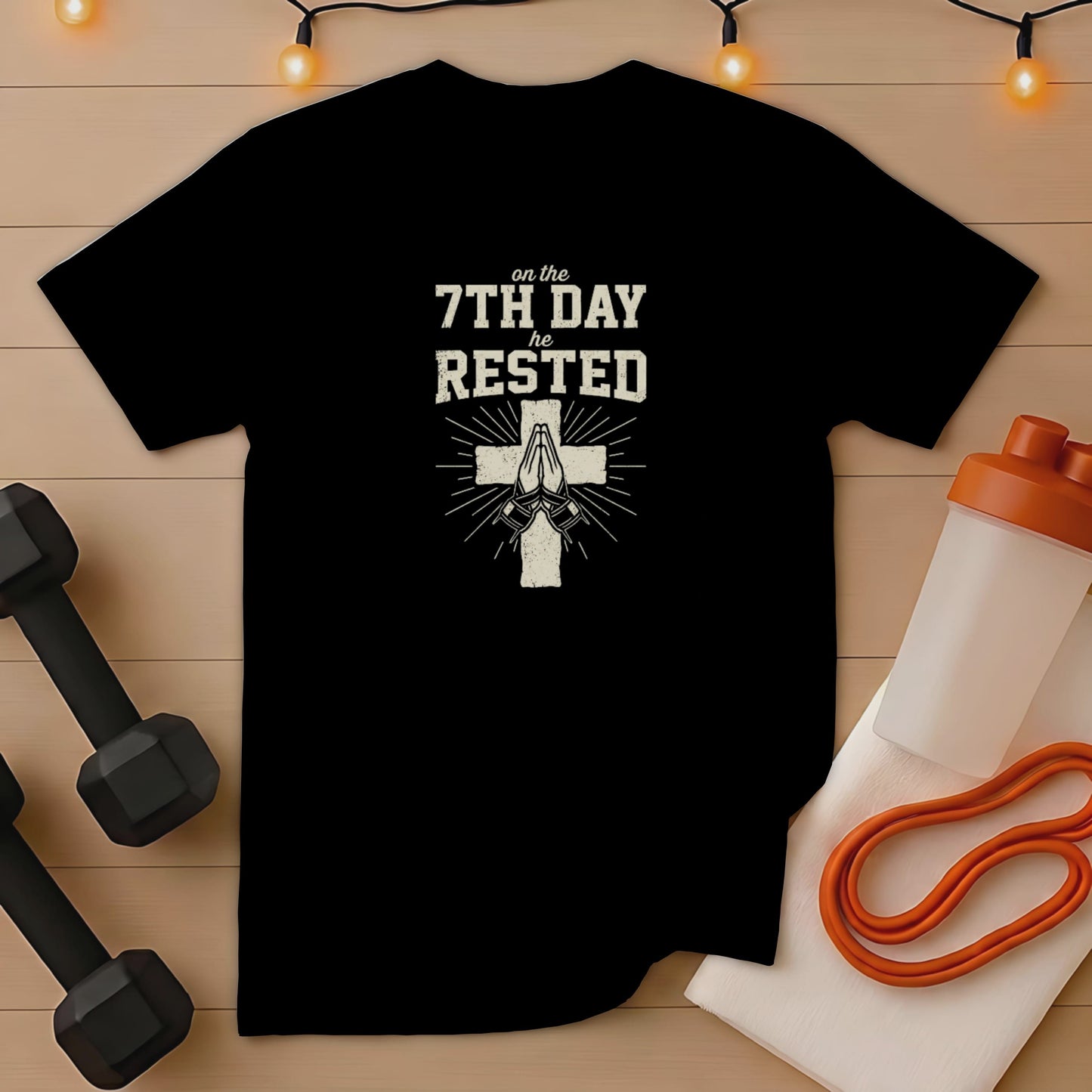 Black t-shirt with "on the 7th day he rested" text and praying hands.