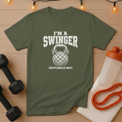 Green t-shirt with text "I'M A SWINGER (KETTLEBELLS ONLY)" and pineapple kettlebell graphic.