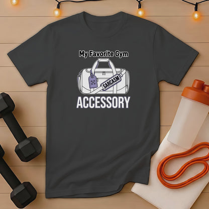 Gray t-shirt with "My Favorite Gym Accessory Sarcasm" graphic, next to dumbbells and shaker.