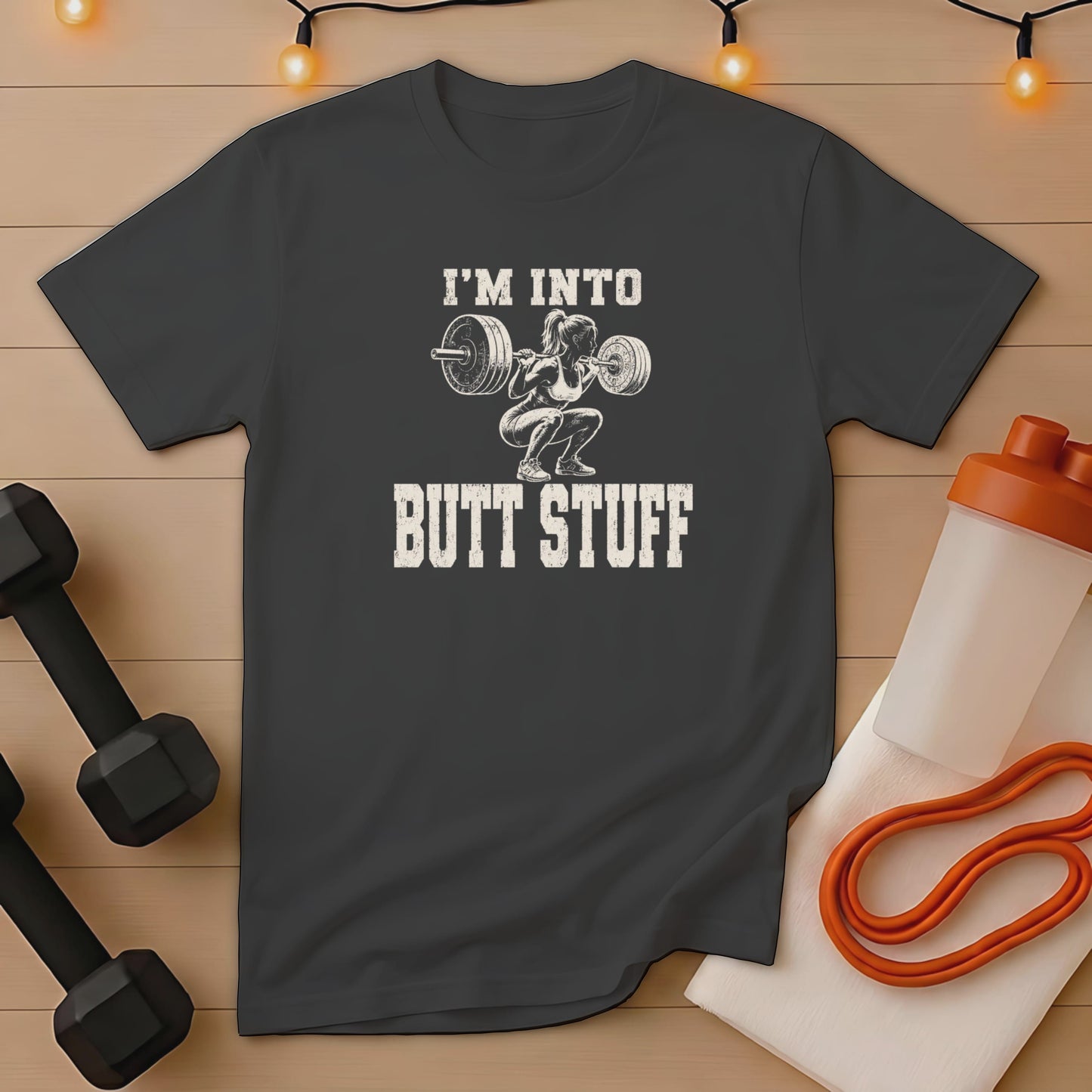 Dark t-shirt with "I'M INTO BUTT STUFF" printed over a squatting weightlifter graphic.