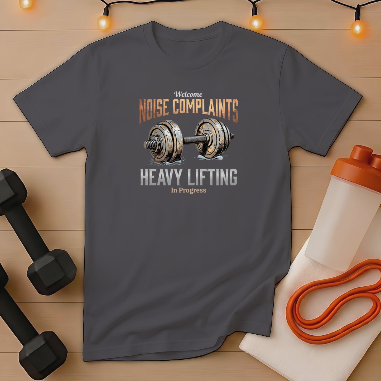 Dark grey t-shirt with "Welcome NOISE COMPLAINTS HEAVY LIFTING In Progress" graphic.