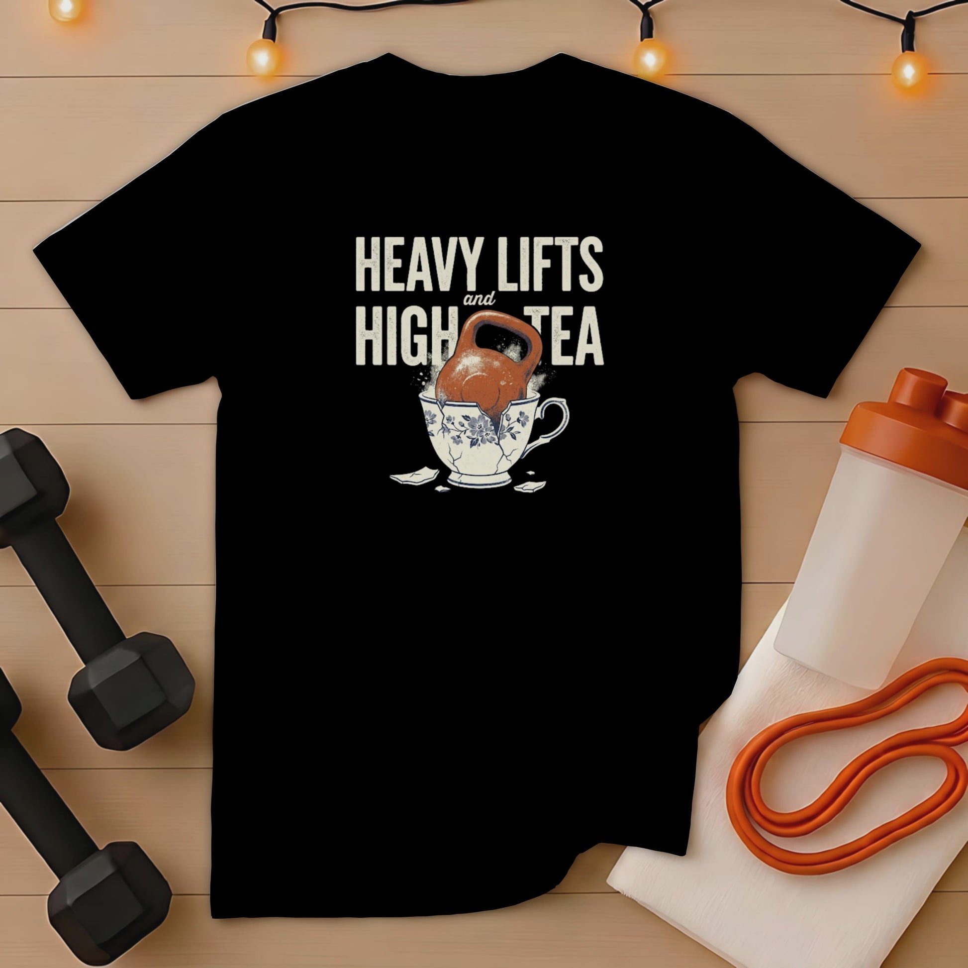 Black t-shirt with "Heavy Lifts and High Tea" text and kettlebell in teacup graphic.