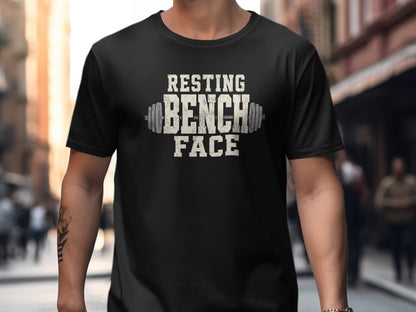 Black t-shirt with textured white text "RESTING BENCH FACE" and barbell graphic.