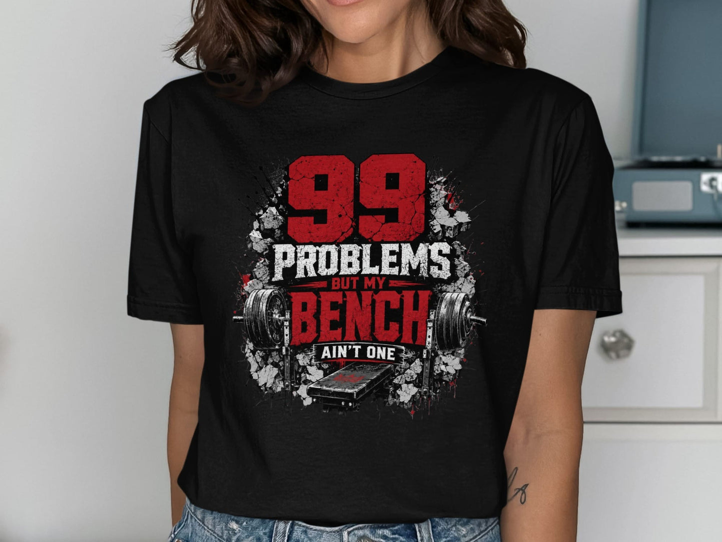 Black t-shirt with "99 Problems But My Bench Ain't One" and weightlifting graphics.