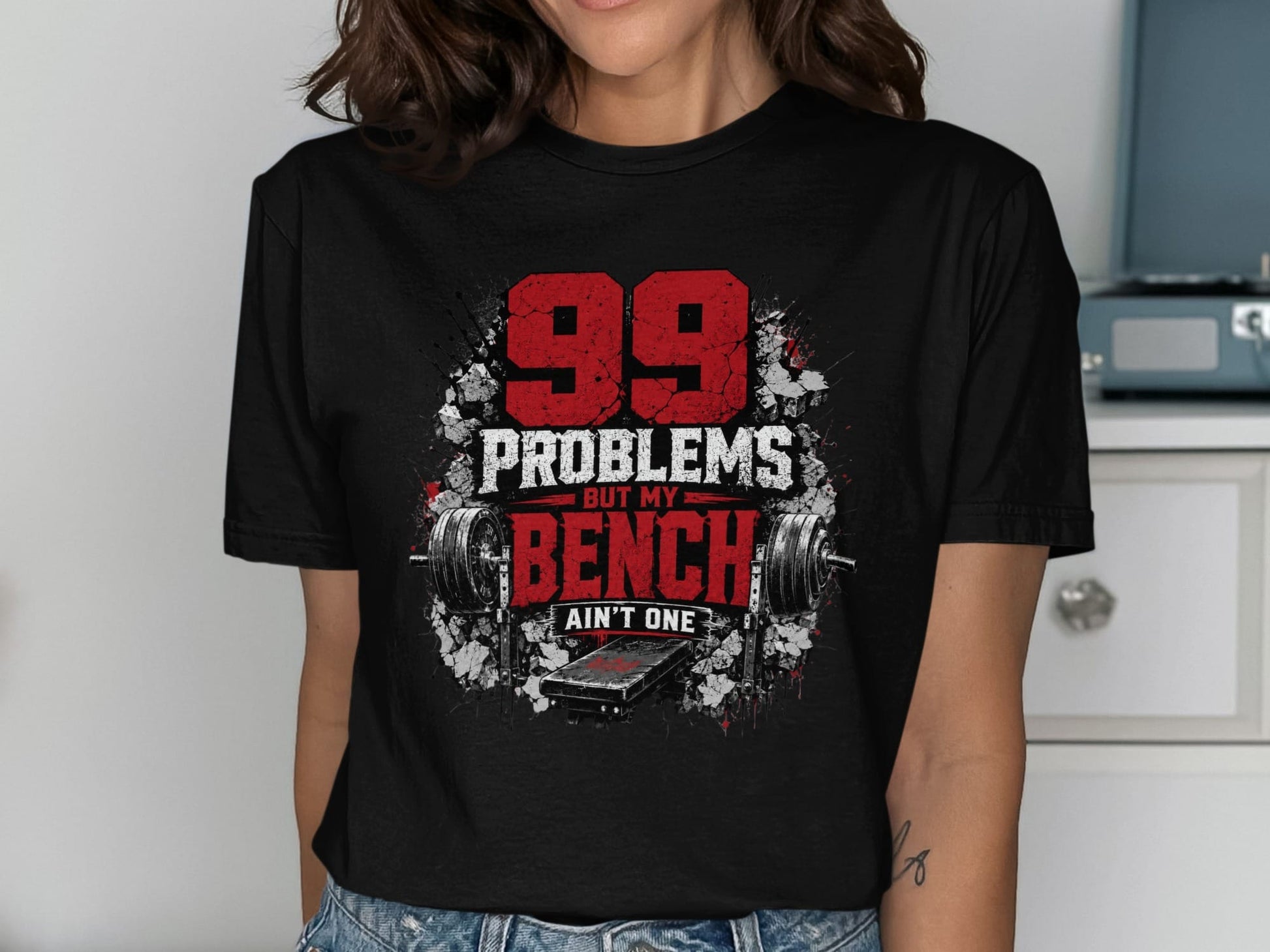 Black t-shirt with "99 Problems But My Bench Ain't One" and weightlifting graphics.