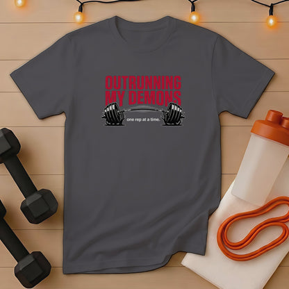 Dark gray t-shirt with "Outrunning My Demons" text and barbell graphic.