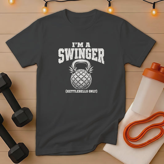 Dark grey t-shirt with "I'M A SWINGER (KETTLEBELLS ONLY)" text and pineapple kettlebell graphic.